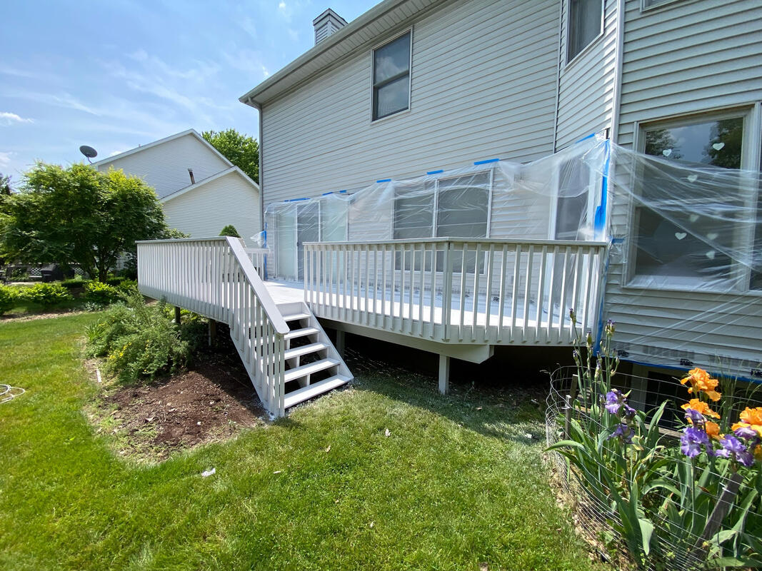 White elevated deck mid-job with window protection still on