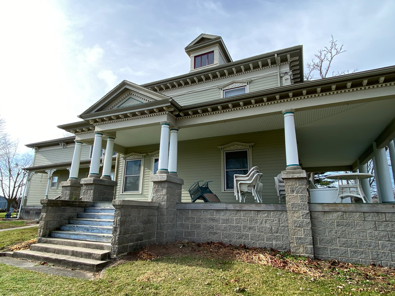 Pale yellow historic house with columned porch
